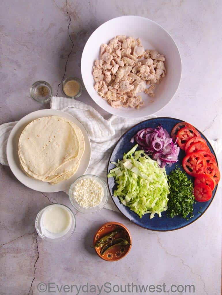 Ingredients for Crispy Chicken Tacos with garnish and cheese