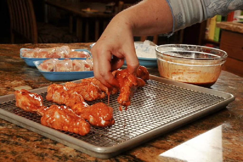 Dip chicken wings in sweet and spicy sauce then roast in the oven