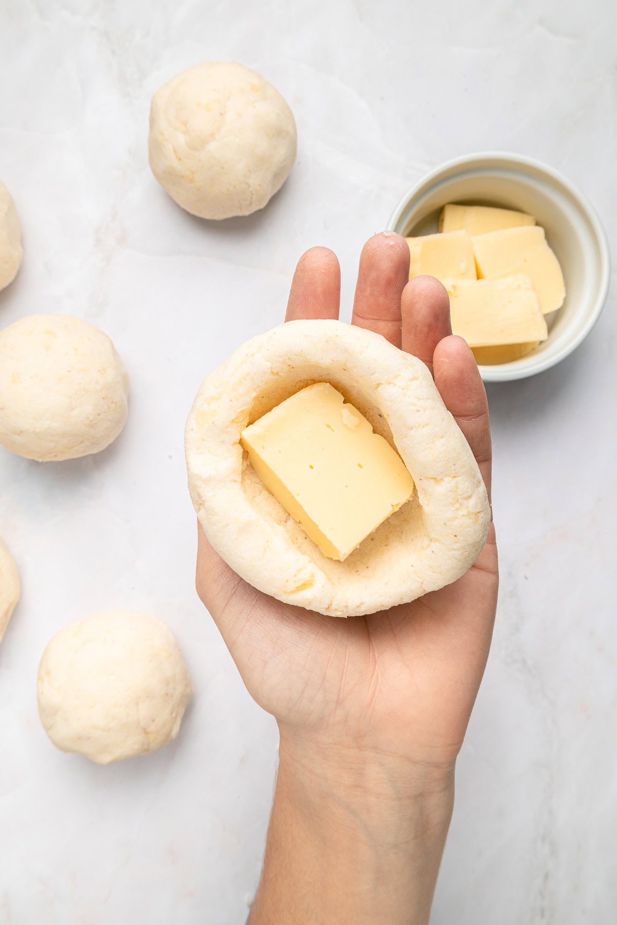 Fitting a piece of mozzarella inside the arepa.