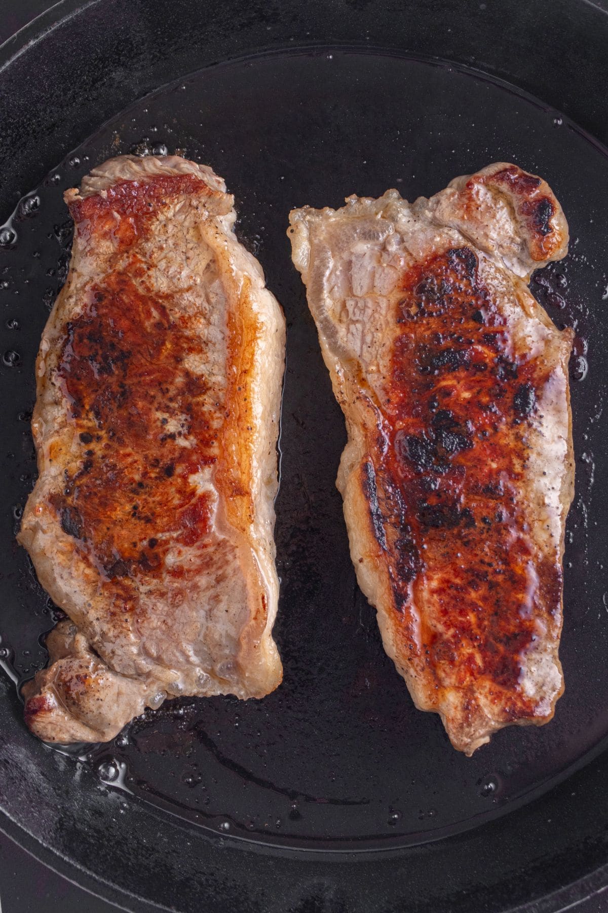 Cooking the steaks in a cast iron skillet.
