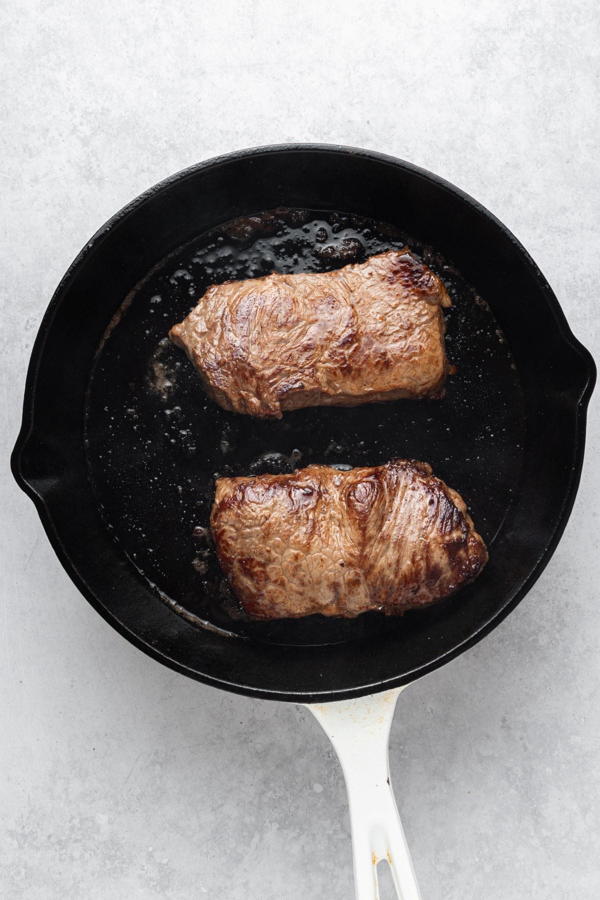 Juicy steaks in a cast-iron skillet.