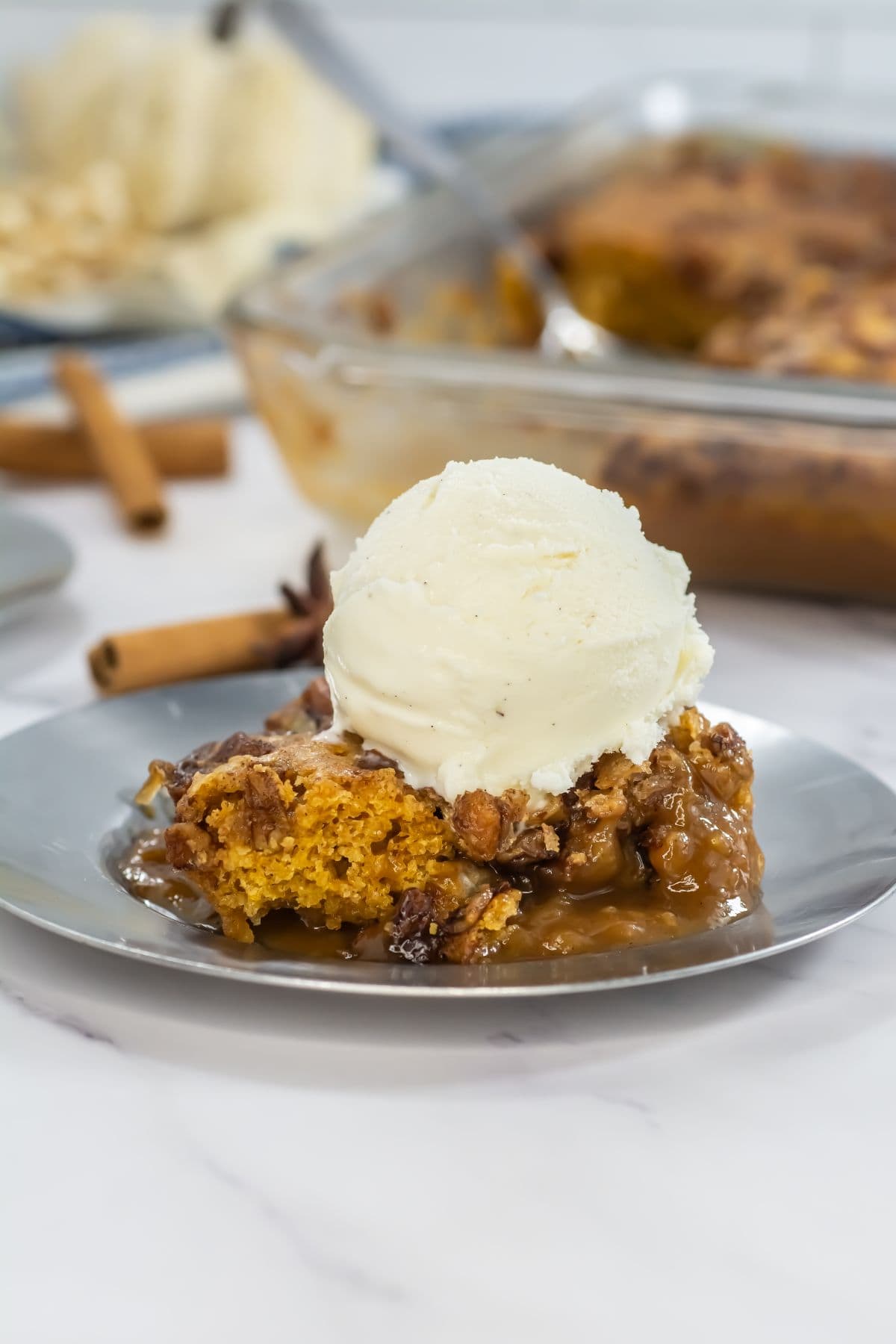 Pumpkin cobbler with pecan topping served with ice cream.