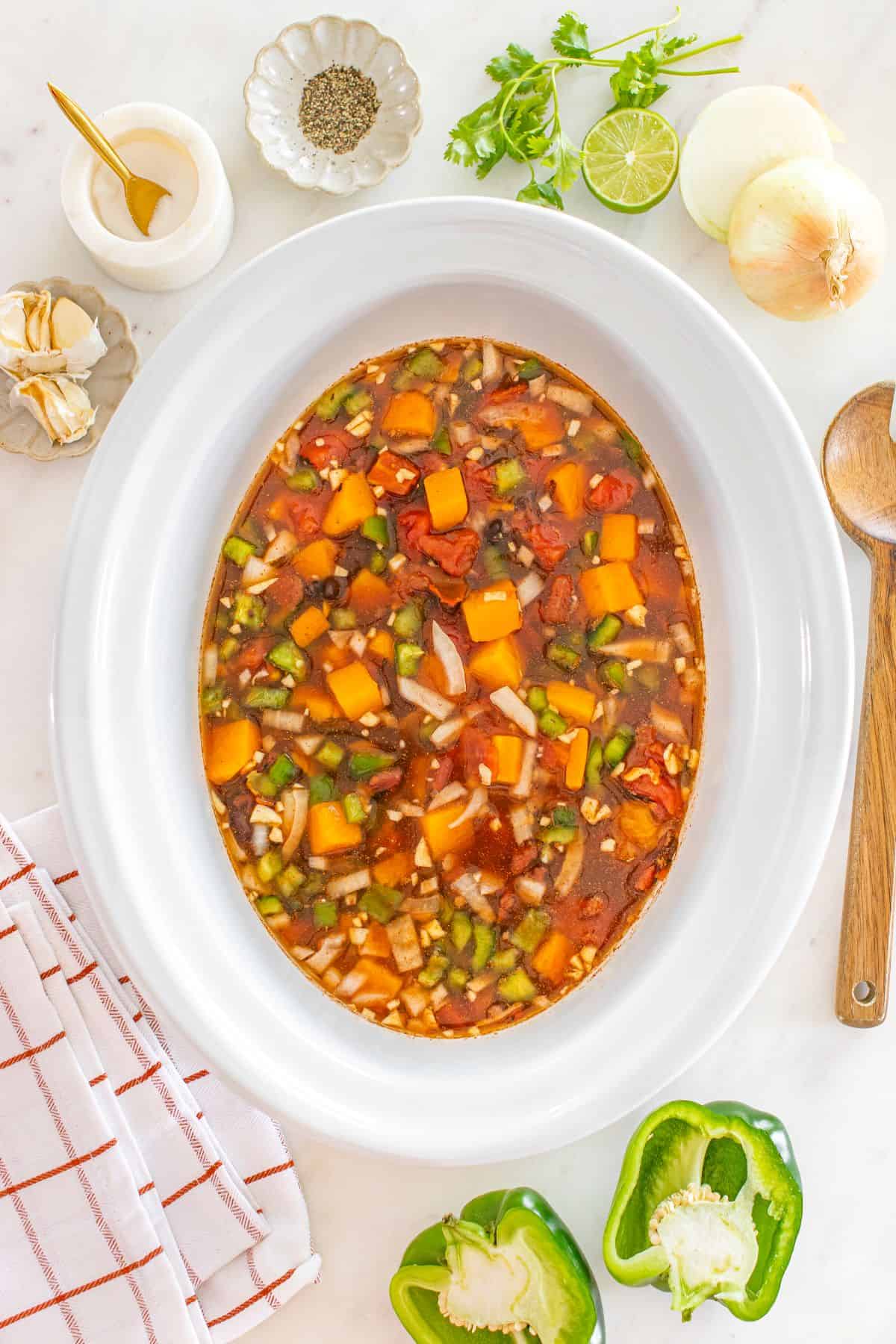 Mixing chopped veggies in the slow cooker.