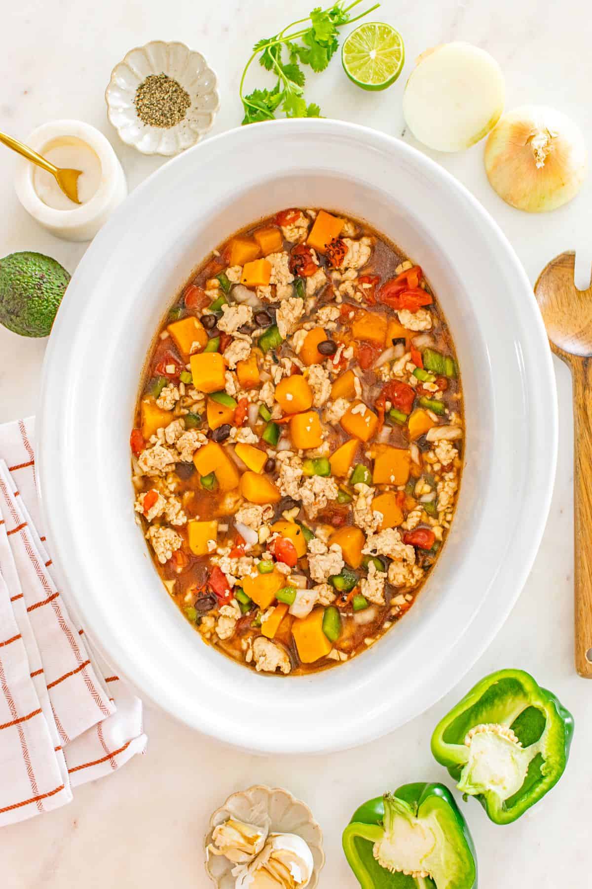 Adding ground turkey to the slow cooker.