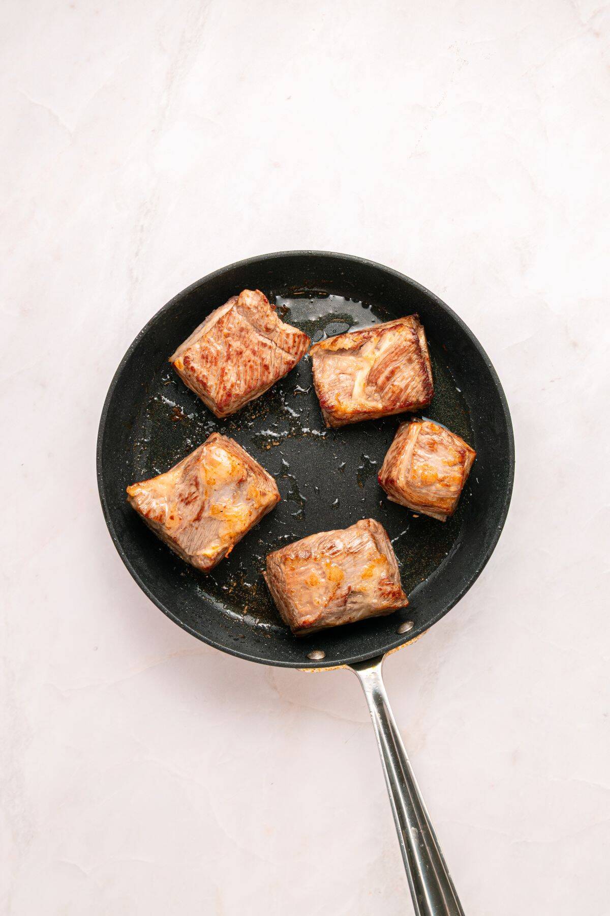 Searing beef short ribs.