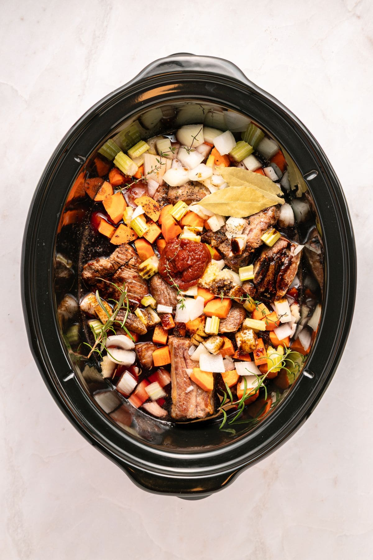 Adding all the ingredients to the slow cooker.