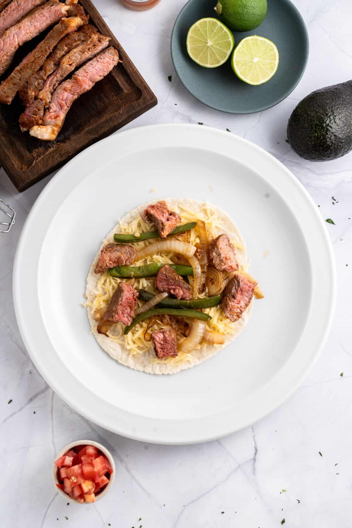 Topping with steak and veggies.