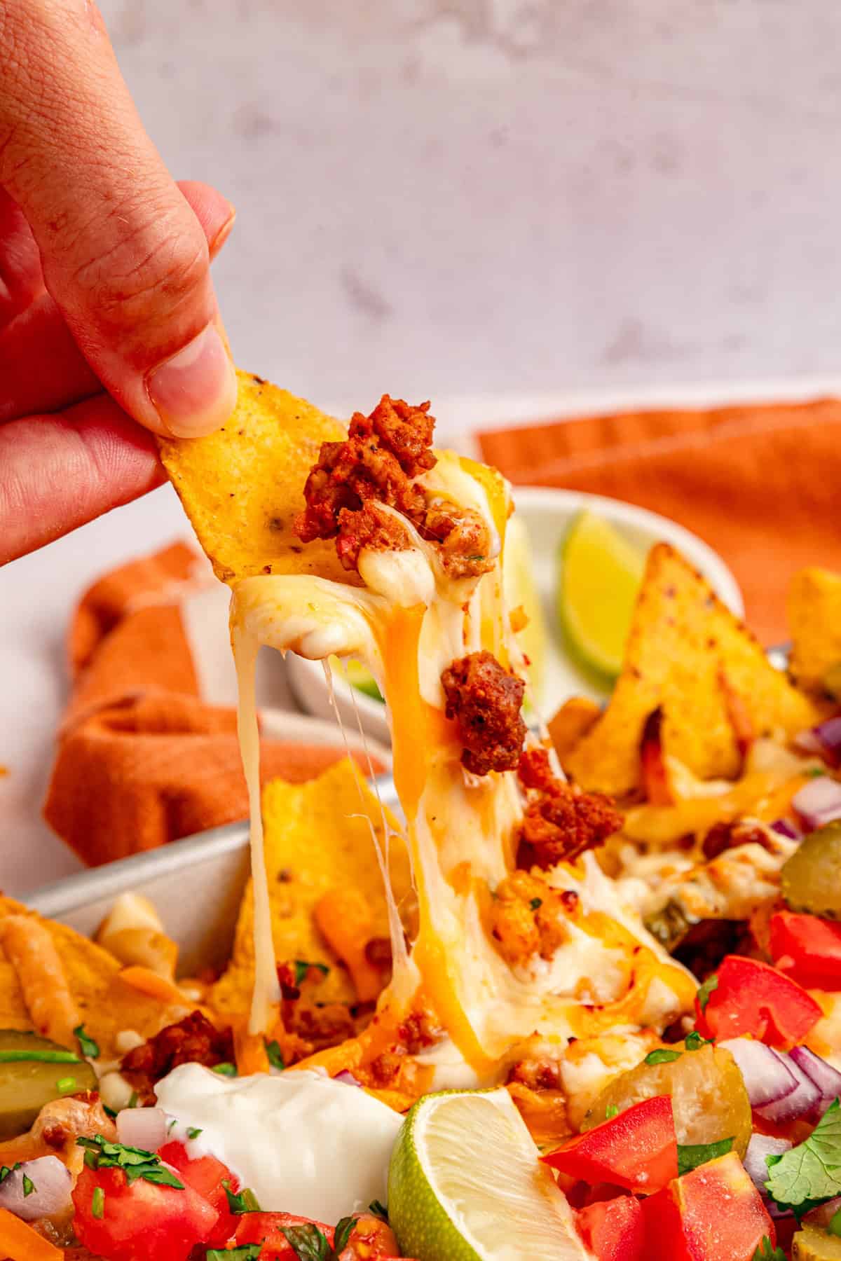 Pulling out a nacho with melted cheese.